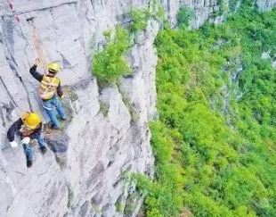捅山工百米高空作業,為保障山下列車通行安全